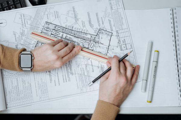 person holding a pencil and a ruler